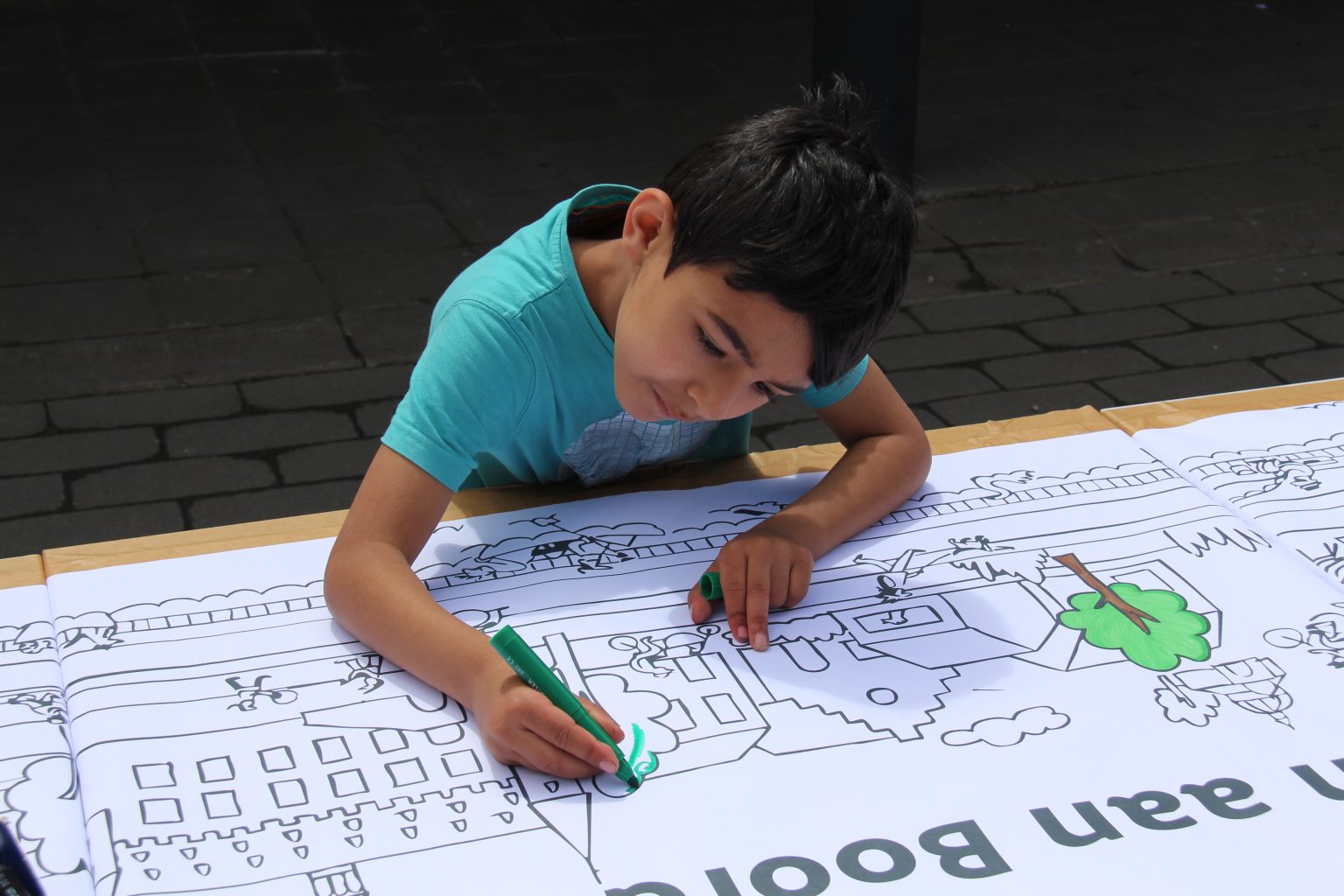 Child coloring a drawing of the Dender river at Kaaifeest participation event
